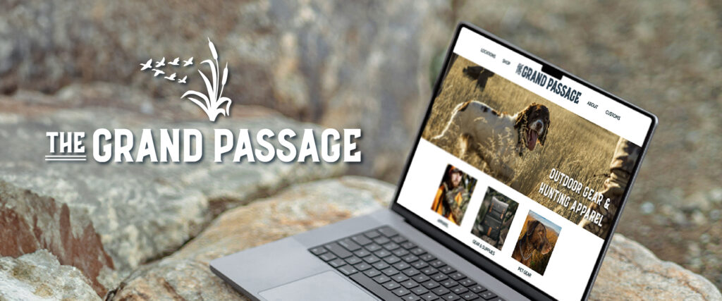 Mockup of a laptop on a rock outside. on the laptop, there is the homepage of an outdoor clothing brand. on the left, there is the logo for the grand passage, a new apparel shop for hunting for sport and outdoor gear